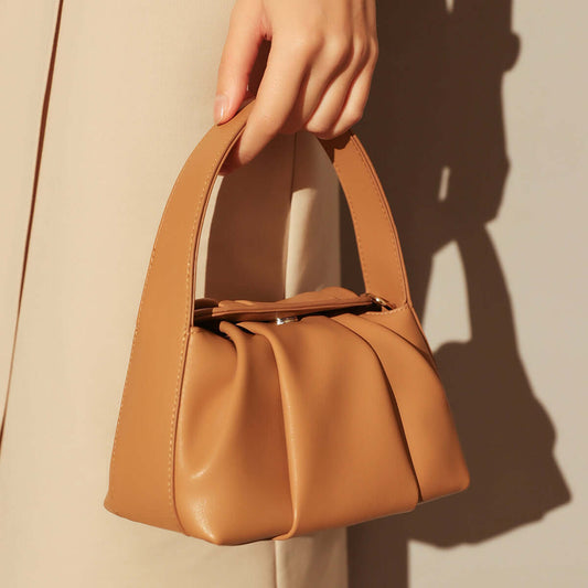 Ruched Leather Handbag held in hand, showcasing elegant pleats and a stylish silhouette.
