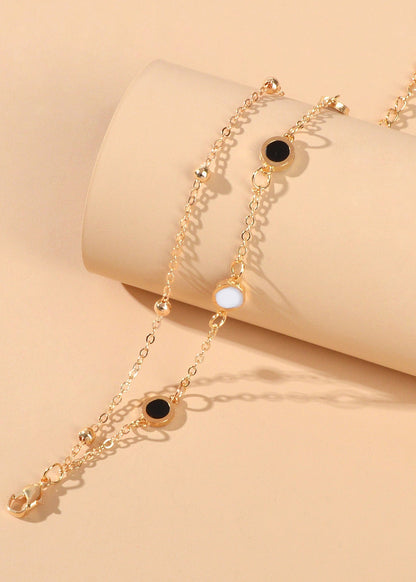 Round Disc Double Layer Bracelet featuring gold chains and black and white disc accents.