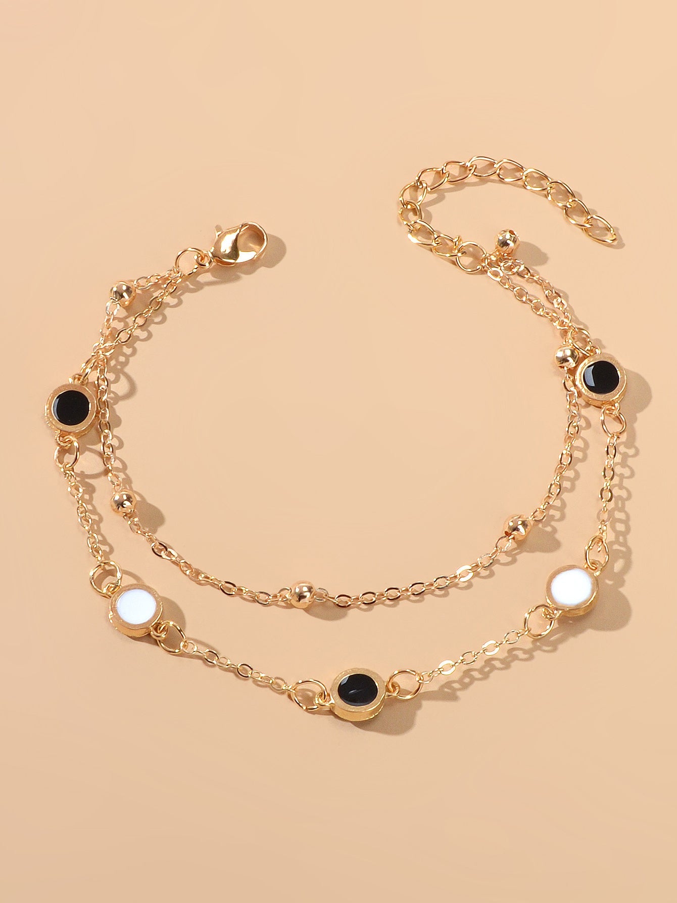 Round Disc Double Layer Bracelet featuring black and white discs with a gold chain.