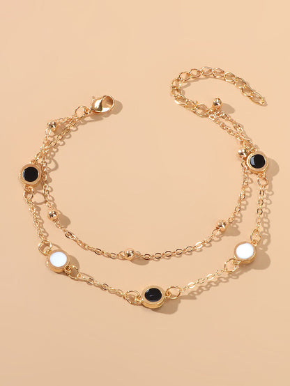 Round Disc Double Layer Bracelet featuring black and white discs with a gold chain.