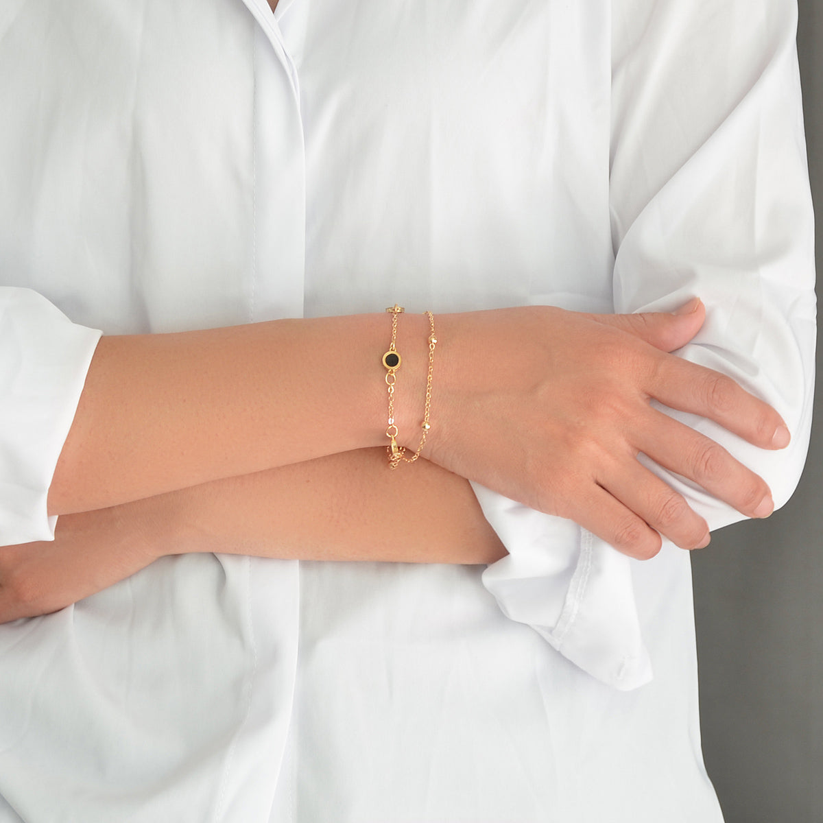 Round Disc Double Layer Bracelet worn on a woman's wrist, featuring a gold design.