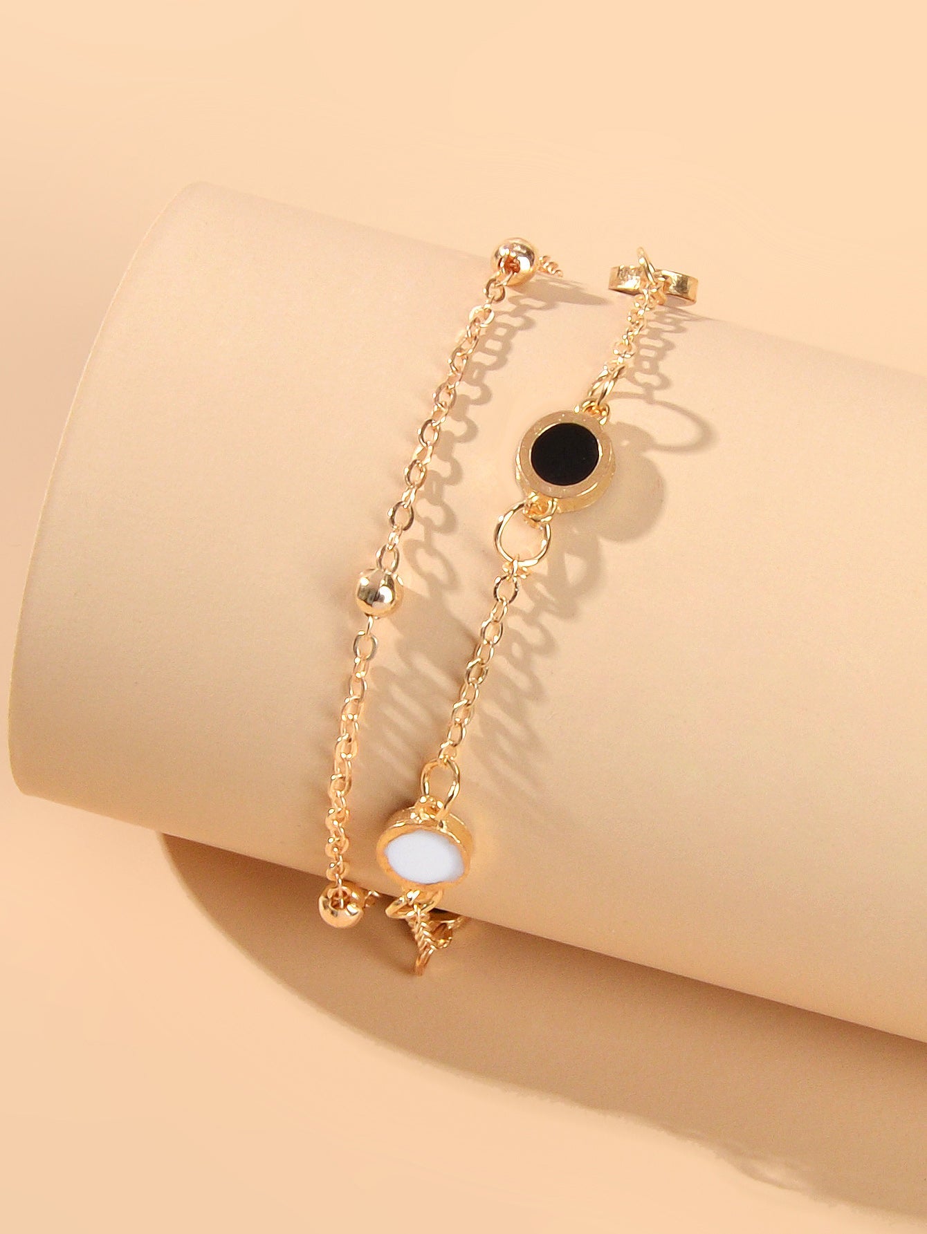 Round Disc Double Layer Bracelet displayed on a neutral background, showcasing elegant design with black and white discs.