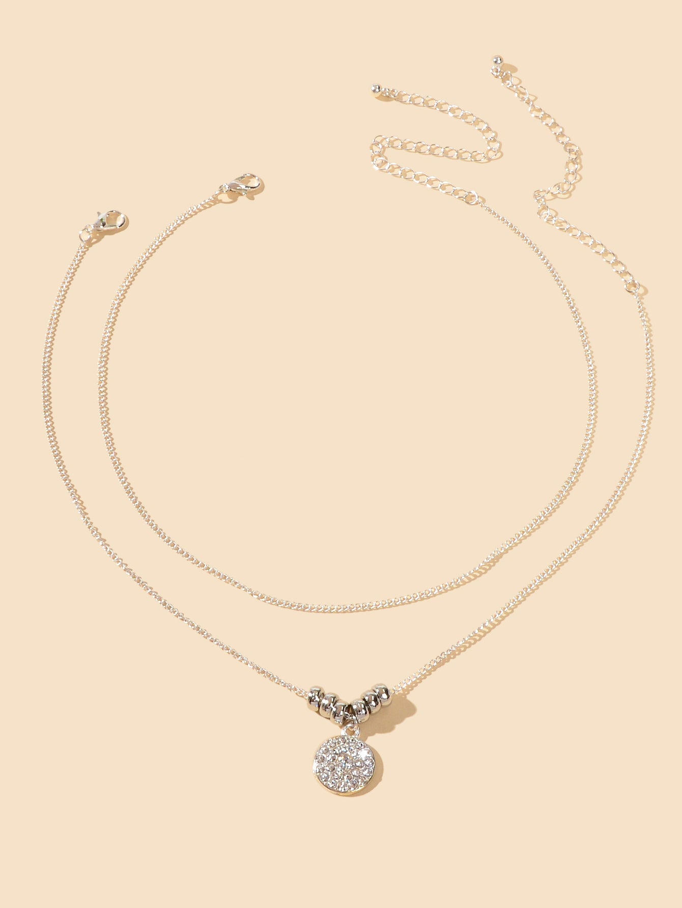 Trendy Jewellery 2 pcs Gold Silver Chain Rhinestone Decor Round Pendant Necklace on a beige background.