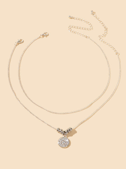 Trendy Jewellery 2 pcs Gold Silver Chain Rhinestone Decor Round Pendant Necklace on a beige background.