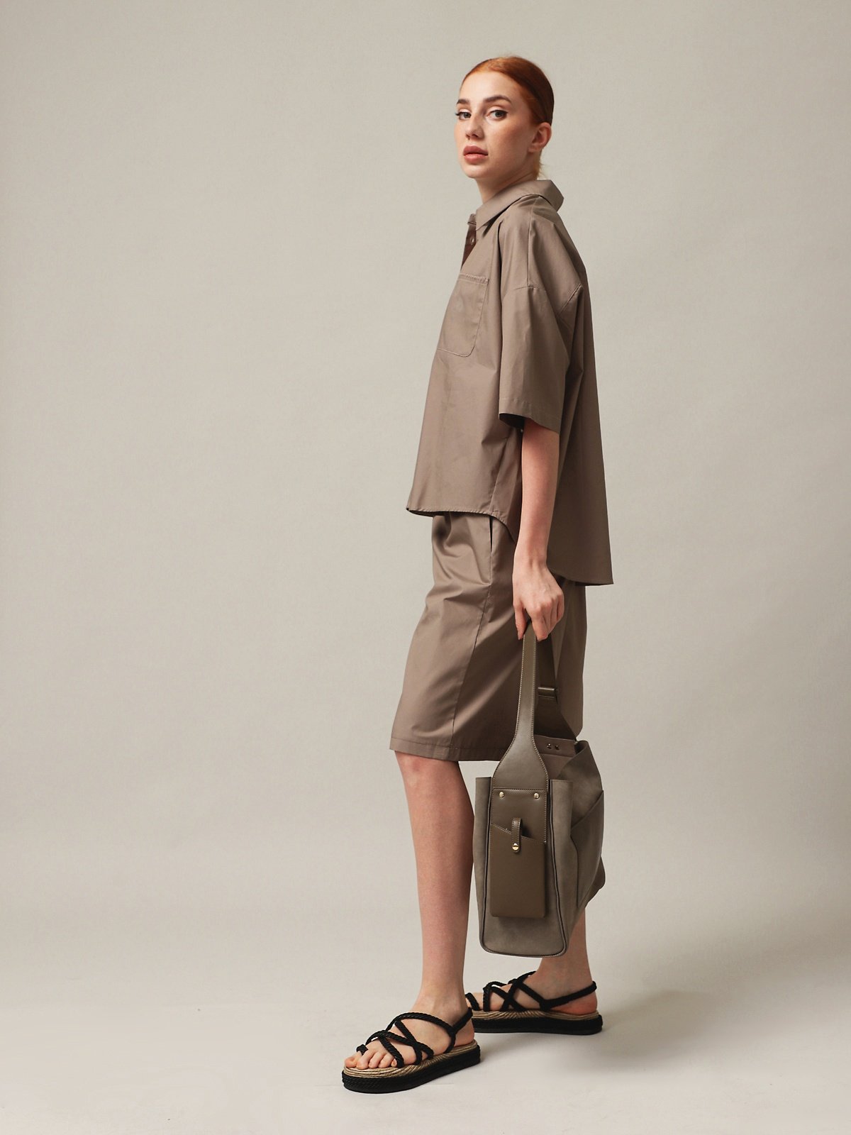 Woman wearing a stylish outfit with a Women's handbag, showcasing a modern and chic look.
