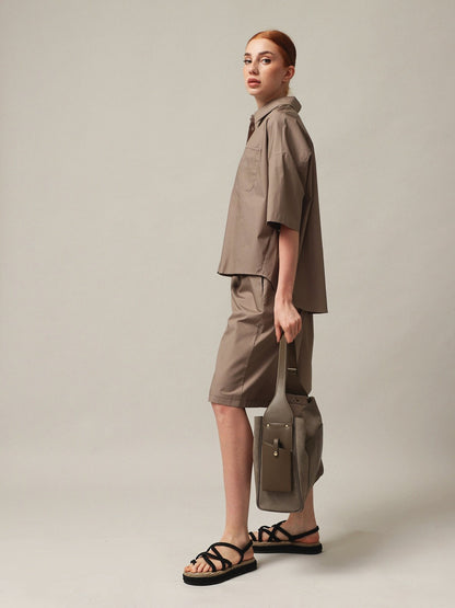 Woman wearing a stylish outfit with a Women's handbag, showcasing a modern and chic look.