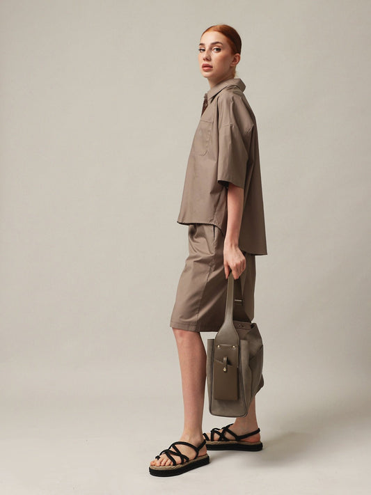 Woman wearing a stylish outfit with a Women's handbag, showcasing a modern and chic look.