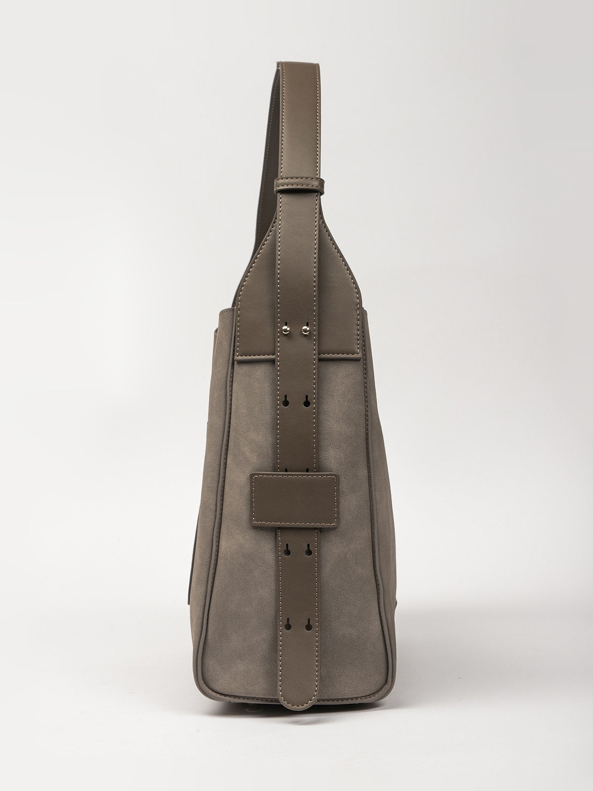Side view of a grey Women's handbag made of 100% suede with dimensions 30.5x13.5x28 cm.