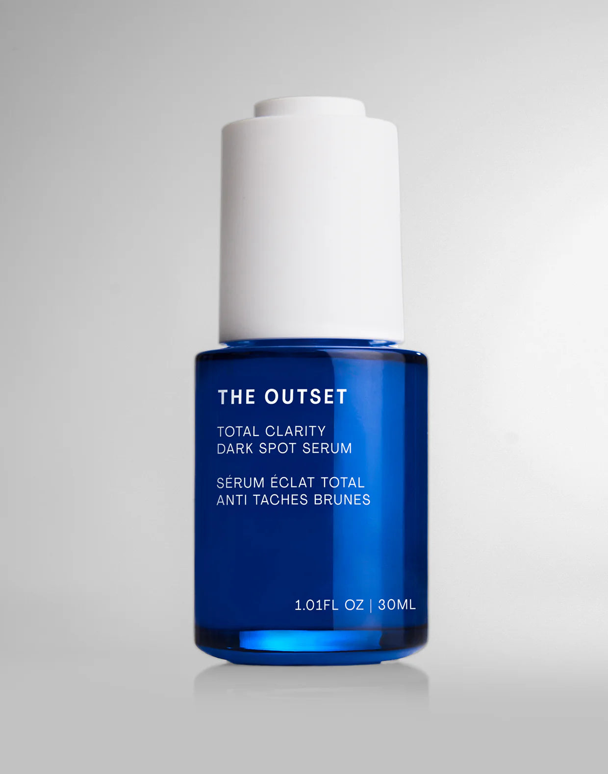 Total Clarity Dark Spot Serum in a blue glass bottle with white cap for brightening skin and fading dark spots.