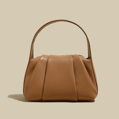 Ruched Leather Handbag featuring elegant pleats and spacious design, perfect for day-to-night transitions.