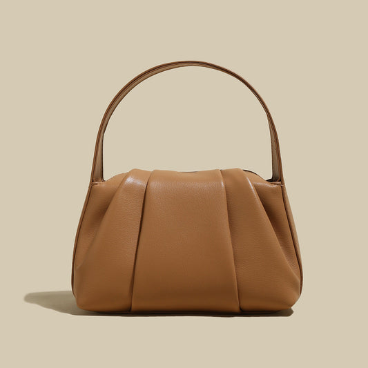 Ruched Leather Handbag featuring elegant pleats and spacious design, perfect for day-to-night transitions.